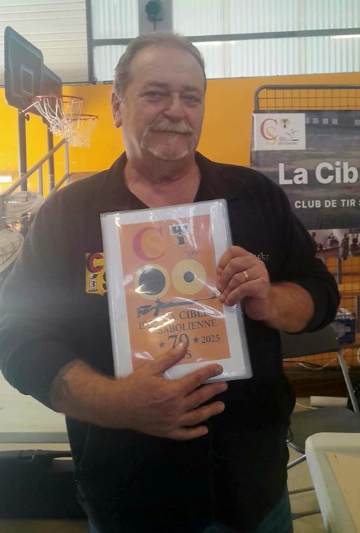 L'animateur de l'école de tir présente le cahier des 70 ans du club